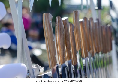 Street Trade. Traditional Fair. The Counter With Handmade Knives. Various Knives With Wooden Handles In A Row.  Daytime. No People. Selective Focus.