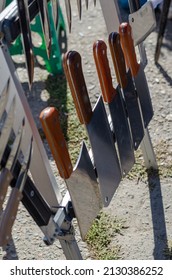 Street Trade. Traditional Fair. Stall With Knives And Handmade Kitchen Axes. The Hand Tools Of The Butcher Or Cook.  Daytime. No People. Selective Focus.