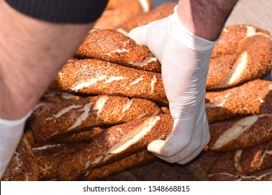 A Street Vendor Wearing Plastic Food Handling Gloves Serving Simit Sesame Seed Rolls / Bread To A Customer In Istanbul