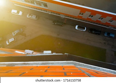 Street View From Above With Parked Cars Between Buildings From Apartment Of Multi-storey House. View From Balcony Down. Look From The Top To Road Between The Houses In Town. Sunrise With Bright Light