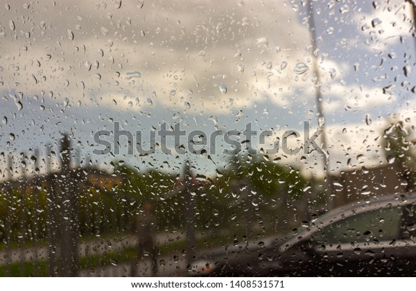 Street view from car\
window with rain drops