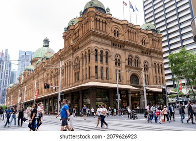Street view of crowd of people crossing light rail tracks in Central Business District near Queen Victoria building Sydney, Australia, 20 November 2021. Busy day at Sydney city downtown.
