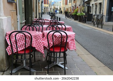 Street View Of Newer Part Of Carcassonne, France. Sidewalk Cafe Tables With Red-white Gingham Pattern Tablecloth.