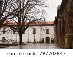 Street view with some trees and a romanic church side in Aviles. Northern Spain street landscape in a cloudy day.