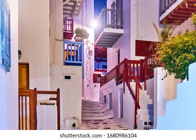 Street With White Small Houses With Balconies In Mykonos Town At Night, Greece