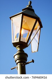 Streetlight Burning During The Day As A Symbol Of Waste, Losses And Vandalism. Broken Hooligans Street Lamp.