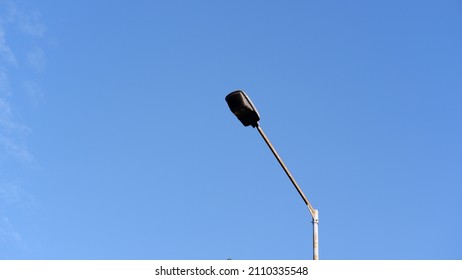 Streetlight pole against blue sky background