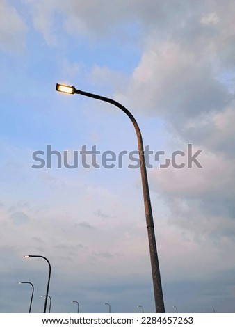 Streetlights that illuminate the street under the blue sky
