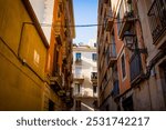 Streets of Barcelona Raval neighborhood seen on a sunny summer day with blue sky. shops, apartments balconies in the city center