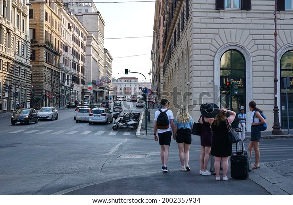 Streets of Rome and tourists, Rome in Italy on\
01.09.2019. Wandering tourists with traveling bags, taking photos\
with cameras, street vendors trying sell their stuff are common\
site in Rome. 