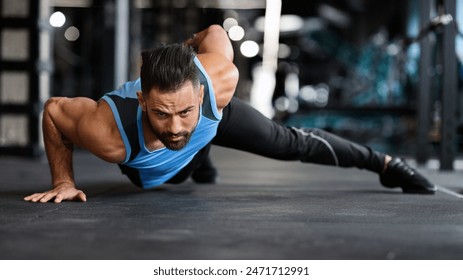 Strength exercise. Muscular man doing push ups on on hands in gym, panorama - Powered by Shutterstock