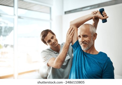 Strength, physiotherapist and mature man with dumbbell in clinic for physical therapy, support or mobility exercise. Fitness, health worker and patient for help, stretching arms or rehabilitation - Powered by Shutterstock