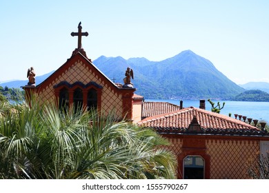 Stresa, Italy - 01 May 2019 Borromeo House, Details Of The Facade Family Chapel, With Beautiful Decorations Made With Terracotta Panels. On The Background The Lake Maggiore.