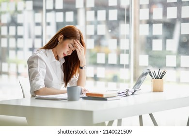 Stress, Business, People, Paperwork And Deadline Concept - Stressed Asian Businesswoman With Papers And Charts Sitting At Table In Office