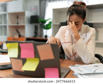 Stress business woman busy and pain from overwork. young adult Asian professional manager having office syndrome at office. beautiful employee upset in pain because working too much overtime work. - Powered by Shutterstock