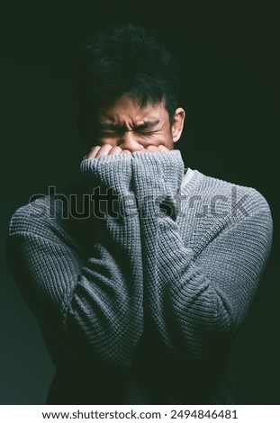 Stress, crying and man in dark studio with hands on face in fear, nightmare and mental health trauma. Angry, scared and frustrated person with depression, anxiety and terror on black background