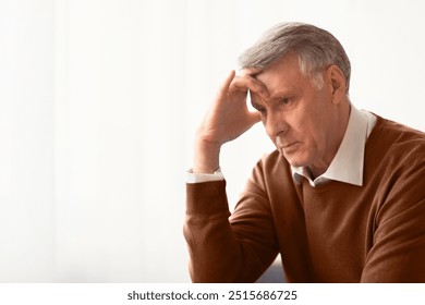 Stress. Depressed Senior Man Thinking About Problems Touching Head Sitting Against Window At Home. Selective Focus, Empty Space - Powered by Shutterstock