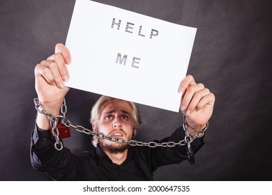 Stress, Depression, Assistance Concept. Scared Man With Chained Hands Holding Help Me Sign, Studio Shot On Dark, Grunge Background