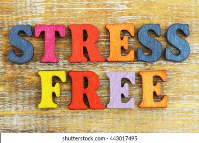 Stress free written with colorful letters on rustic wooden surface
