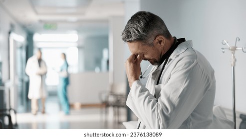 Stress, grief or fail with a mature doctor in a hospital looking unhappy for healthcare or medical. Depression, mistake or loss with a sad man medicine professional in a professional medicare clinic - Powered by Shutterstock