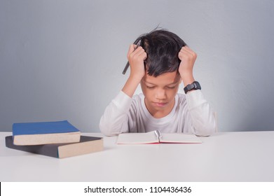 Stress Kid Doing Homework.Boy At Study Table Doing Homework With Stress Action.Lazy Boy Doing Homework With Stressed Face.