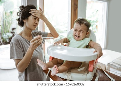 Stress Mother While Feeding Her Baby At Home