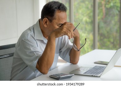 Stress Older Man Taking Off Glasses From Tired Dry Irritated Sore Eyes After Long Computer Use. Asian Elderly Male Feels Pain Blurry Vision Working On Laptop. Optical Overuse Syndrome (Selective Focus