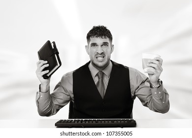 Stress Out Businessman  Holding A Filofax In One Hand And A Swash Up Paper Coffee Cup In The Other Hand