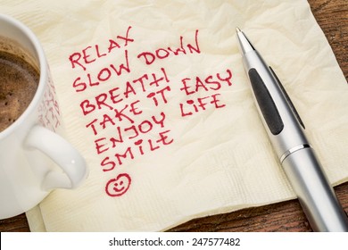 Stress Reduction Concept - Relax, Slow Down, Breath, Take It Easy, Enjoy Life, Smile Handwriting On A Napkin With A Cup Of Coffee