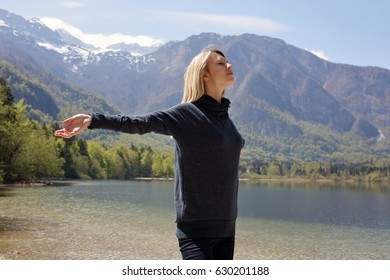 Stress Relief Activities. Freedom Concept. Woman Breathing Fresh Air And Enjoying Beautiful Mountain Lake Landscape. Take A Break, Relax, Dream ,smile