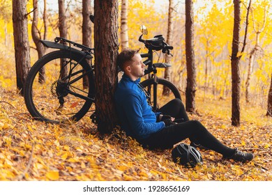 Stress Relief Activities, Simple Pleasures And Workout Outdoor. Tired Cyclist Is Sitting On Fall Leaves In Forest And Resting. Togetherness With Nature