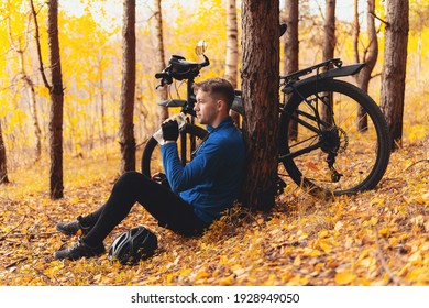 Stress Relief Activities, Simple Pleasures And Workout Outdoor. Tired Cyclist Is Sitting On Fall Leaves In Forest And Resting. Togetherness With Nature