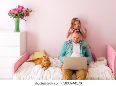 Stress Unhappy Busy Dad Working With Laptop At Home In Pink Kid Room Interior. Child Girl Playing And Make Hair Style. Parent At Home Office Because Of Covid 19. Fathers Day With Daughter At Home.