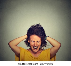 Stress. Woman stressed is going crazy pulling her hair in frustration isolated on gray wall background. Negative human emotions feelings reaction 