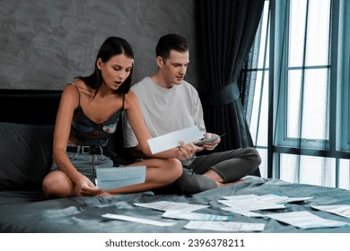 Stress young family couple worried about overwhelming and massive credit card bill or final mortgage loan notification. Modern family financial crisis from over spending online shopping. Unveiling - Shutterstock ID 2396378211