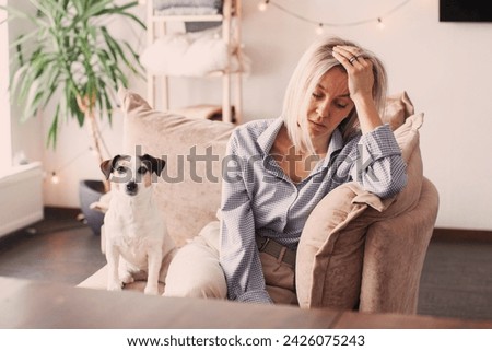 Stressed Adult Woman sitting on Sofa. Middle-aged female is Worried