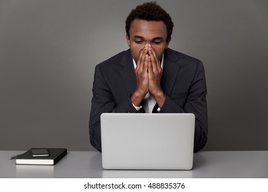 Stressed African American businessman is looking at his laptop screen. Concept of crisis and bad news receiving - Shutterstock ID 488835376