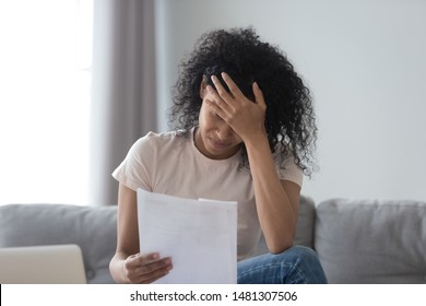 Stressed african American young woman hold paper document feel distressed with eviction notice or dismissal notification, upset black female read letter get bad news from correspondence mail - Shutterstock ID 1481307506