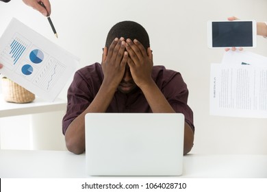 Stressed african businessman tired or difficult multitasking job covering face with hands avoiding annoying colleagues or clients, exhausted fatigued black worker suffers from stressful work concept