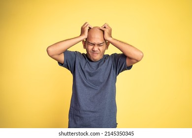 Stressed Asian Bald Young Man Holding Head