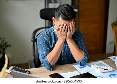 Stressed Asian businessman or male business startup entrepreneur suffering from his anxiety, feeling upset with his work performance. failure, exhausted, crying, no work passion. - Powered by Shutterstock