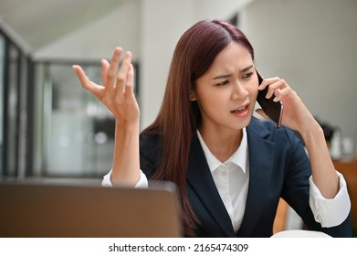 Stressed asian businesswoman or female marketing manager arguing on the phone with her colleague. Serious, Unhappy, Unsatisfied, Mad businesswoman.