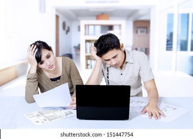 Stressed Asian Couple Paying Bill At Home