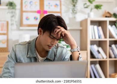 Stressed Asian man suffering from a strong migraine squeezing his head. Serious man have a headache with problem of him work. eye pain problem - Shutterstock ID 2181956551