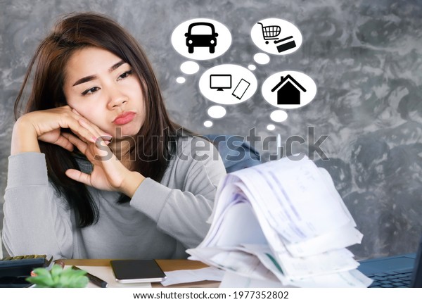 stressed\
Asian woman with financial problems looking at monthly expenses\
debt bills, invoices for car and home loan \
