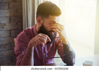 Stressed bearded man in glasses making break