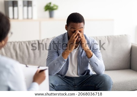 Stressed black guy having session at psychologist's office, receiving professional help in solving personal problems. Psychotherapy, treatment of depression and anxiety concept