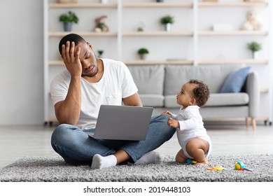 Stressed Black Man Trying To Work With Laptop At Home While Little Baby Distracting Him, Tired African American Father Suffering Difficulties With Remote Job And Paternity Leave, Free Space