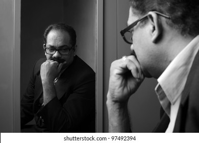 Stressed business man seeing his reflection in the mirror