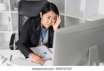 Stressed Business Woman Working at Computer in Modern Office Environment, Experiencing Work Pressure and Fatigue - Powered by Shutterstock